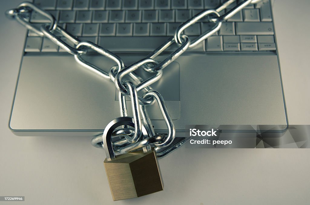 computer security series laptop with chain and locked padlock - shallow depth of field Business Stock Photo