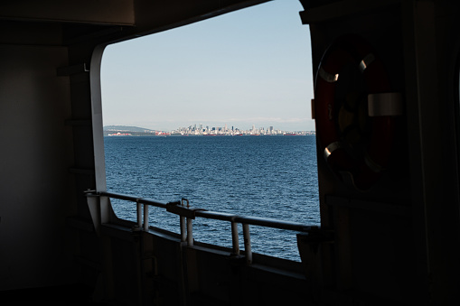 View across bay to Vancouver city skyline from ferry window