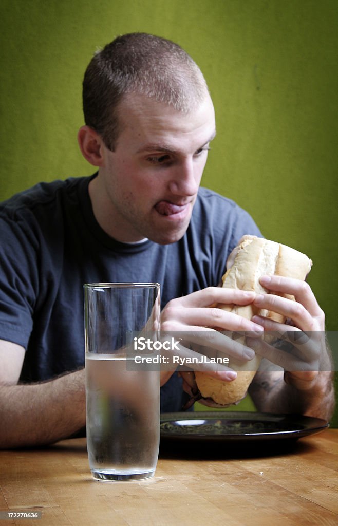 Hungrig junger Mann über seine Sandwich zu essen - Lizenzfrei Begehren Stock-Foto