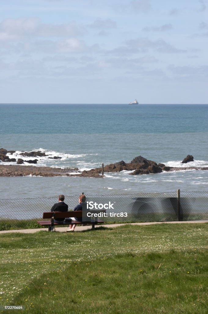 Coppia sulla panchina al mare cliff percorso - Foto stock royalty-free di Bude