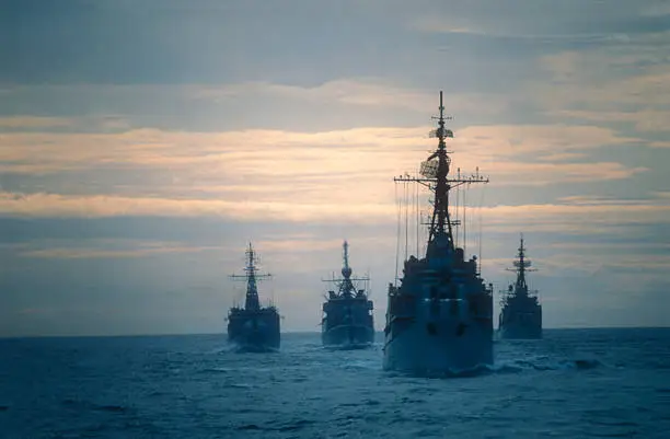 Four frigates doing an exercise on the ocean at the end of the day.I used a slide film