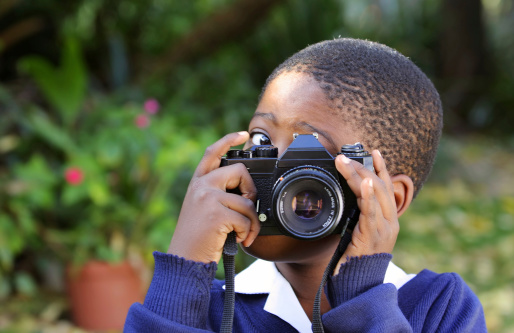 A young schoolboy using an slr camera.