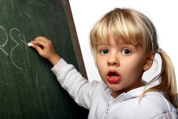 istock Little girl with question confused look writing on a blackboard 172271480