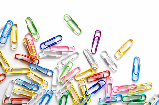 Close-up of multi-colored paper clips on a white background.