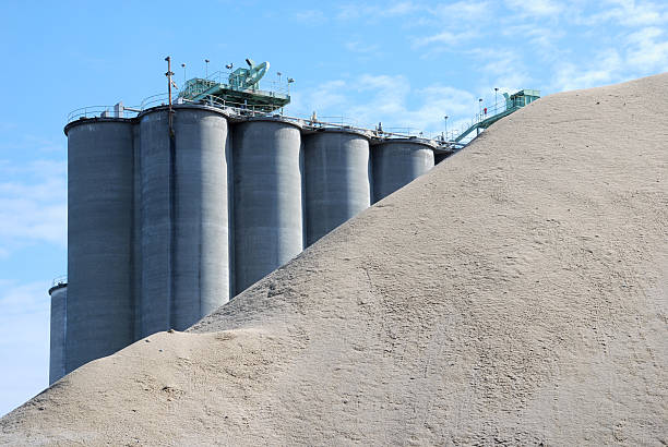 Concrete Plant Concrete Plant behind a pile of sand.  The sand is used in making the concrete. cement factory stock pictures, royalty-free photos & images
