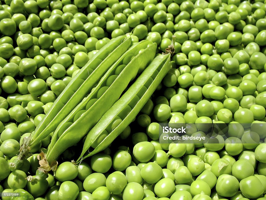 Green Peas Three pea pods on a bed of green peas.Please see some similar pictures from my portfolio: Like Two Peas In A Pod Stock Photo