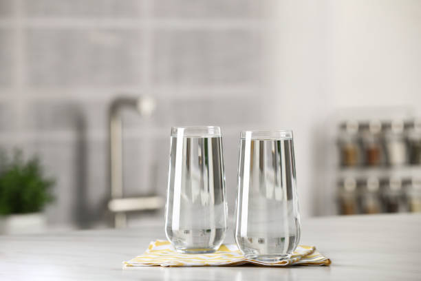 istock Glasses of pure water on white table indoors 1722737852