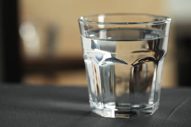 istock Glass of pure water on black table against blurred background, space for text 1722738457