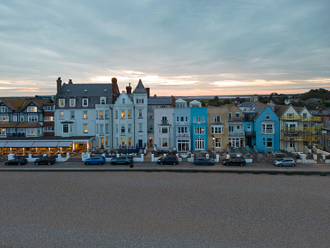 Colourful townhouses seen during dusk at the English seaside resort of Aldeburgh, Suffolk. The shingle beach is deserted.