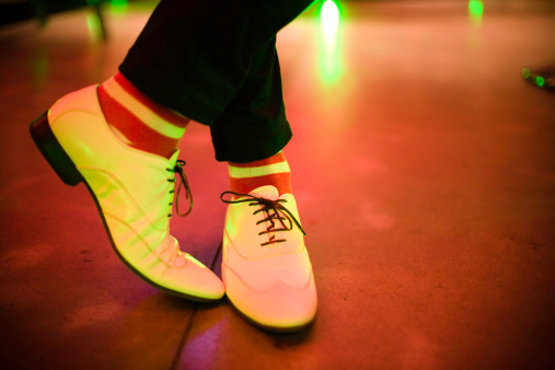 A pair of white shoes waiting at the disco.