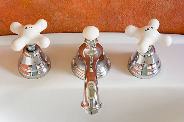 torneira de água quente e fria spigots no lavatório de porcelana instalação - heat sink imagens e fotografias de stock