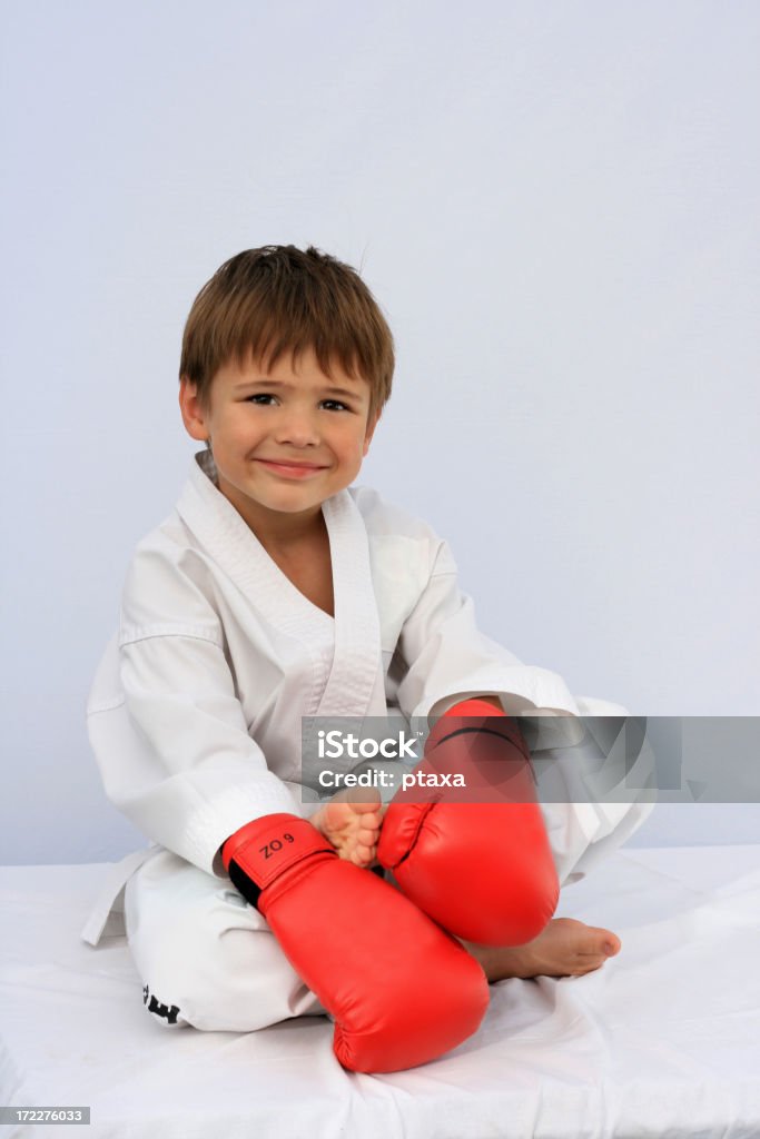 Boy in martial arts uniform Smiling cute boy in martial arts uniform and boxing glovesMore photos about family sport Activity Stock Photo