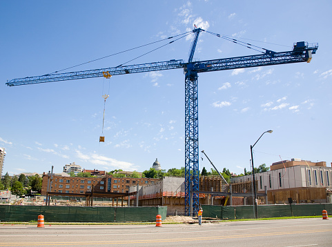 A construction site crane in the process of lifting a box.