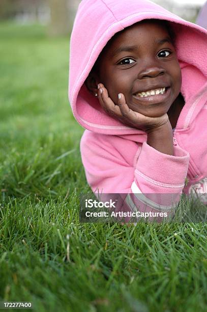 Photo libre de droit de Fillette Heureuse Souriant Dans Lherbe À Lextérieur banque d'images et plus d'images libres de droit de 6-7 ans