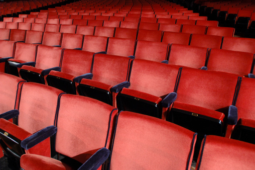 Rows of red seats within a giant concert hall.