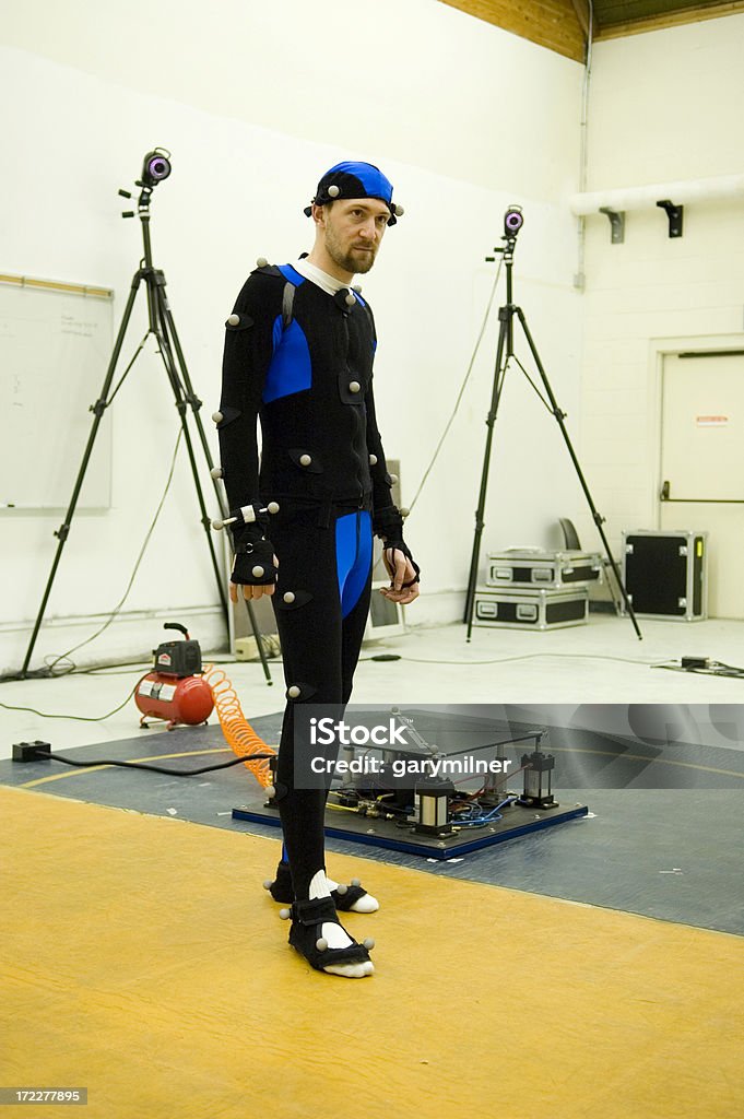 Motion Capture Actor A man in a motion capture suit in a motion capture studio.  Could be for movie special effect, video game production or computer animation. Studio - Workplace Stock Photo