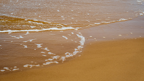Soft sea wave on the sandy beach. Baltic Sea coast, Latvia.