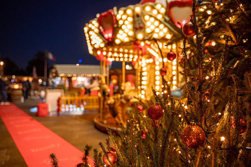 Christmas market carousel with Christmas tree at Italian advent market at night