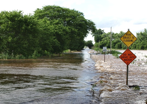 Flooded rural road with flood warning signs in Oklahoma June 2007. Horizontal image. Below is a vertical view and when the flood waters were considerably higher