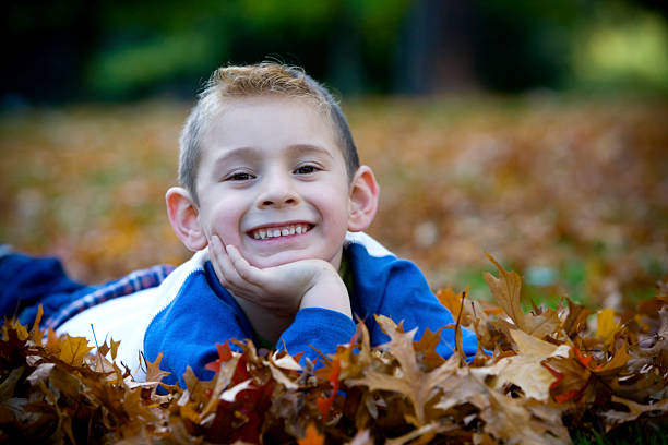 istock Adorable Little Boy Lying on Leaves, Chin in Hand, Copyspace 172278946