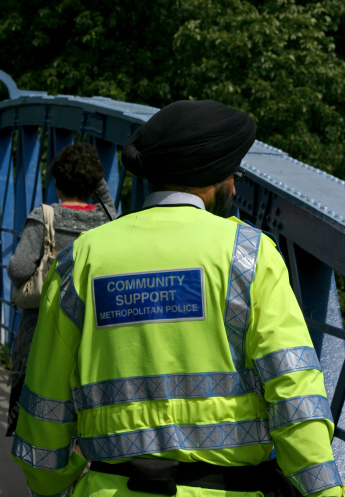 Asian Community Support Police Officer standing on a bridge over the River Thames