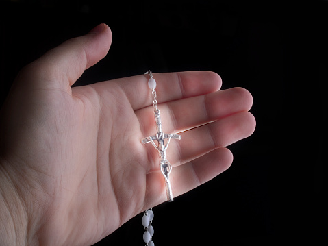 necklace with crucifix in human hand. concept for faith and religion
