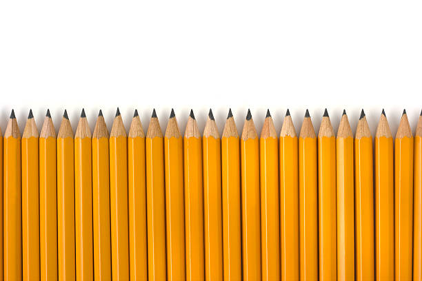 Row of Yellow Pencils Repetition for Education on White Background Subject: A row of yellow pencils against a white background, designed to be used as border for page layout, with space for text above. repetition stock pictures, royalty-free photos & images