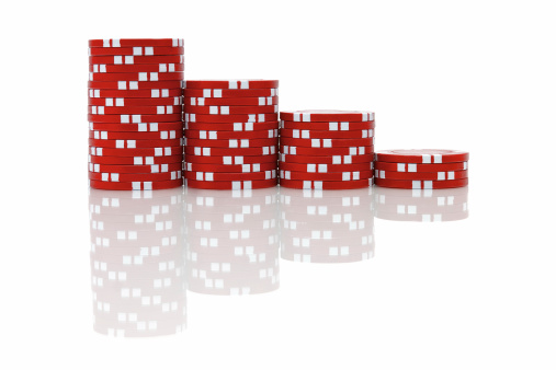 Red clay poker chips with real reflection all on a perfect white background.