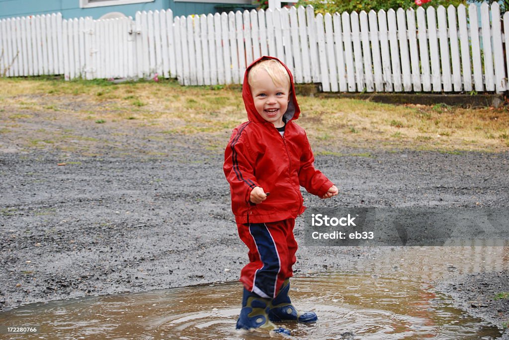 Puddle Jumper A young boy grins as he splashes in a rain puddle.   Autumn Stock Photo