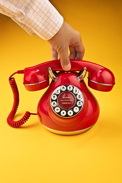 красный ретро телефон на оранжевом фоне - retro revival telephone human hand toned image стоковые фото и изображения