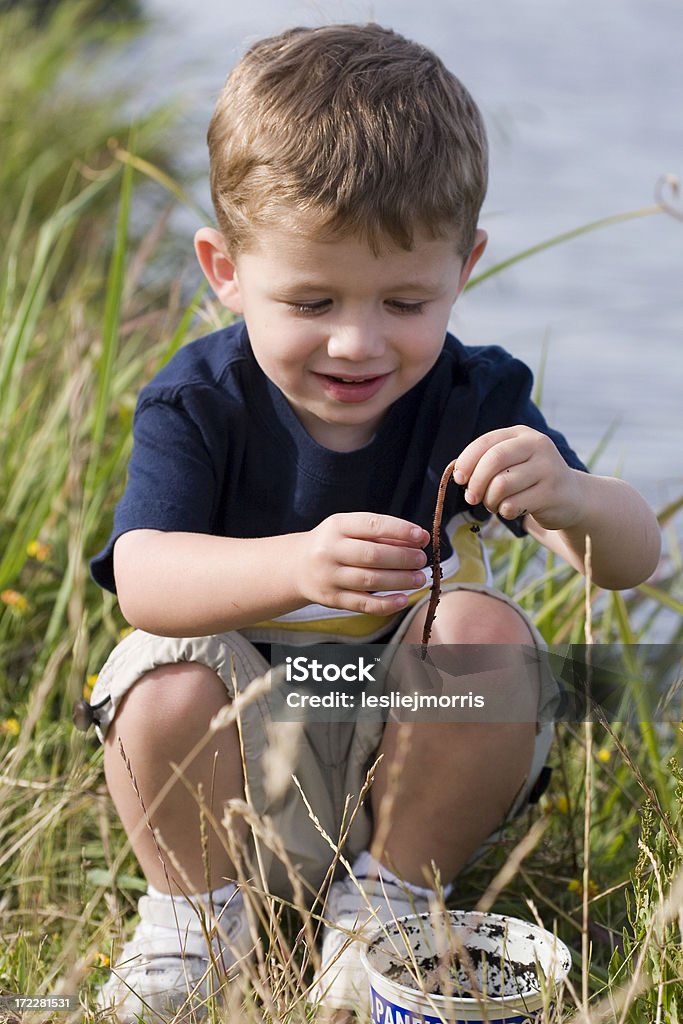 Giovane ragazzo guardando worm Accovacciarsi - Foto stock royalty-free di Bambini maschi