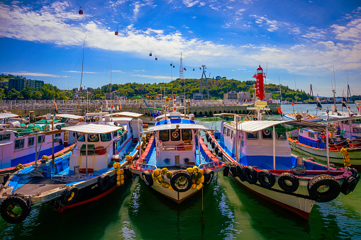 Fishing trawlers moored at Hamel Lighthouse harbor under the cable cars in Yeosu City, South Korea