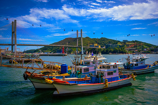 Fishing trawlers moored under Dolsan Bridge harbor under the cable cars station in Yeosu City, South Korea