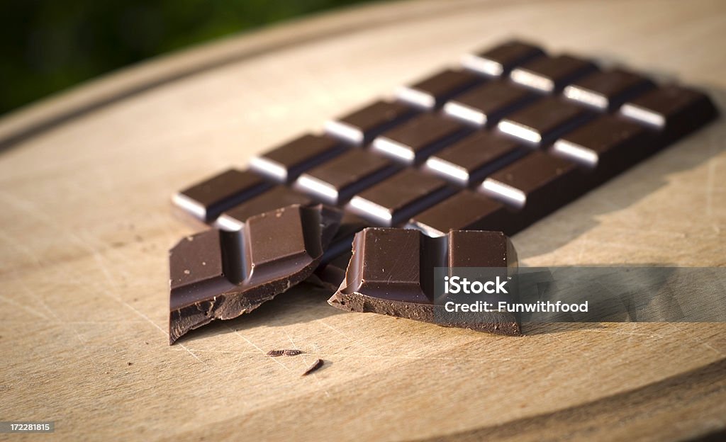 Bar of Dark Chocolate Candy Dark chocolate candy bar on a cutting board. (SEE LIGHTBOXES BELOW for many more chocolate candy, baking, and desserts photos...) Angle Stock Photo