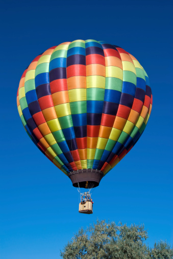 An Aerial View on a Striped Hot Air Balloon Floating Over a Countryside Community, on a Beautiful Summer Day