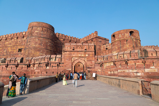 3rd February, 2020 - Agra, India: The Red Fort, a UNESCO World Heritage site, stands as an enduring symbol of India's rich history and Mughal architectural prowess. Both tourists and local visitors are seen exploring the massive fort complex. Built primarily of red sandstone, the fort once served as the main residence of the Mughal emperors. Notably, from various points within the fort, one can catch distant views of another iconic landmark, the Taj Mahal. The people in the photographs are engaged in various activities, from taking selfies to enjoying the panoramic views, making this a bustling hub of cultural interaction and historical exploration.