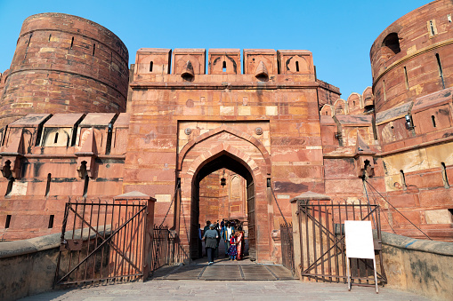 3rd February, 2020 - Agra, India: The Red Fort, a UNESCO World Heritage site, stands as an enduring symbol of India's rich history and Mughal architectural prowess. Both tourists and local visitors are seen exploring the massive fort complex. Built primarily of red sandstone, the fort once served as the main residence of the Mughal emperors. Notably, from various points within the fort, one can catch distant views of another iconic landmark, the Taj Mahal. The people in the photographs are engaged in various activities, from taking selfies to enjoying the panoramic views, making this a bustling hub of cultural interaction and historical exploration.