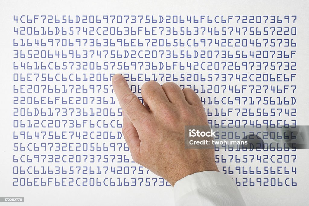 Sequences of digits Computer analyst reviewing a hexadecimal code stream. Right hand pointing at the center of a print. Close-up. Adult Stock Photo