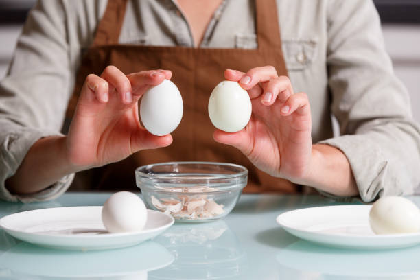 istock Female hands holding boiled eggs - one in shel and another one unshelled. 1722828459