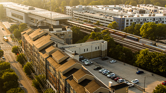 Rail service to Downtown in the morning. Deserted suburban row houses and parking among the railroad of Atlanta, GA. King Memorial Station commute transport. Aerial view