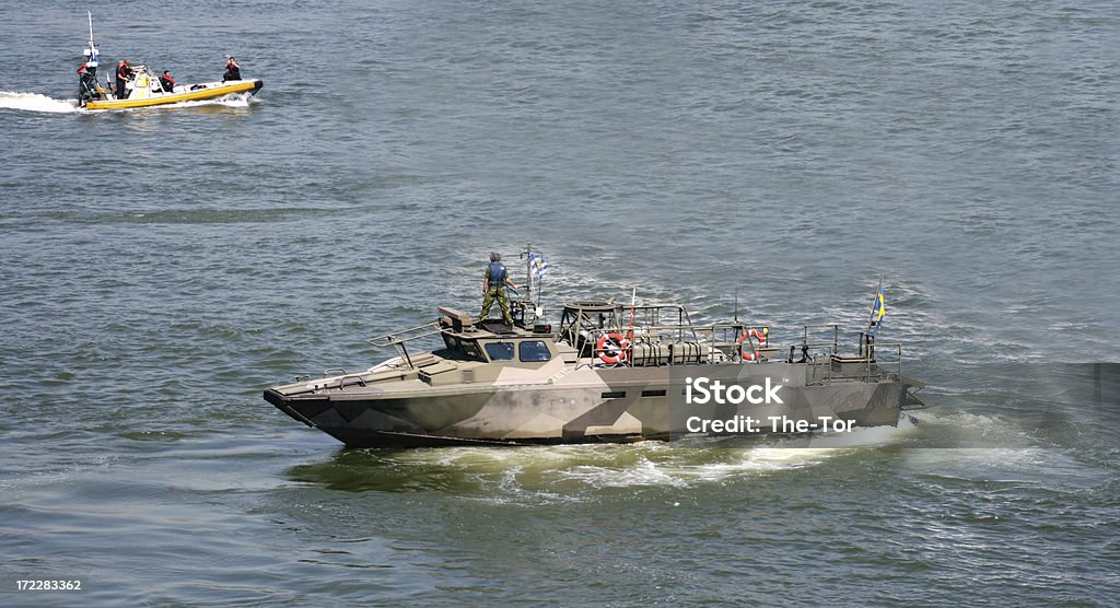 Military Ship A military ship wathing a speed boat. Swedish Military Stock Photo