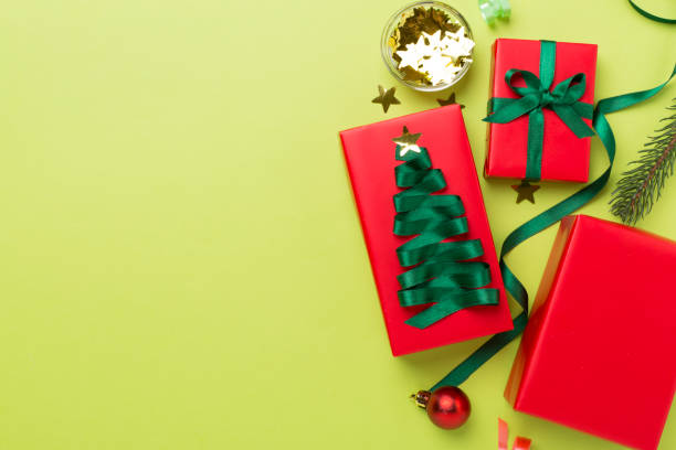 istock Gift boxes with paper's rools and christmas decoration on color background, top view 1722839913