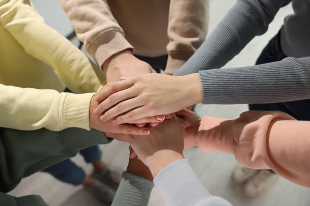 istock Group of people holding hands together indoors, above view. Unity concept 1722847525