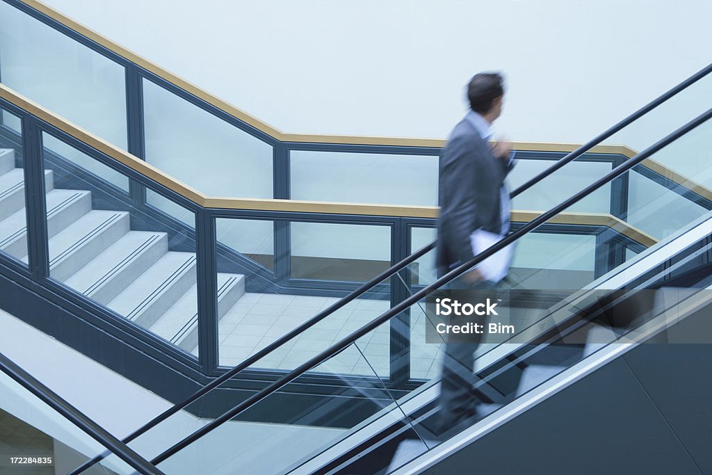 Empresarios en escalera mecánica - Foto de stock de A la moda libre de derechos