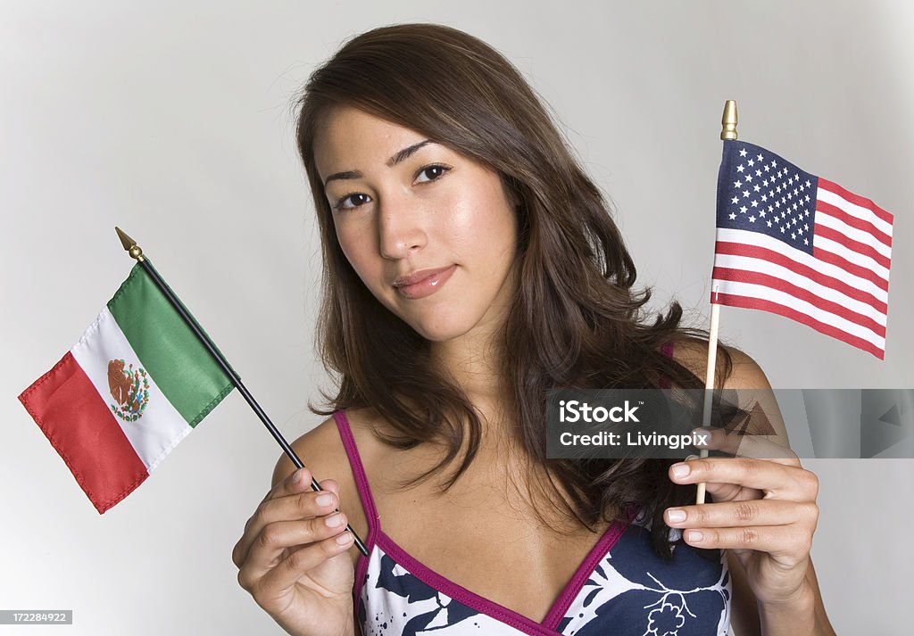 Молодой испаноязычных женщин проводит небольшой мексиканские и американские флаги - Стоковые фото Звёздно-полосатый флаг роялти-фри