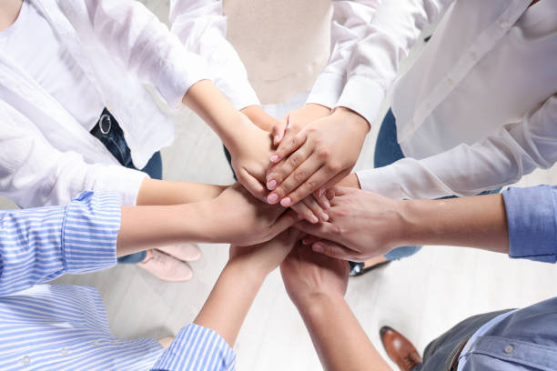 istock Group of people holding hands together indoors, above view. Unity concept 1722850775