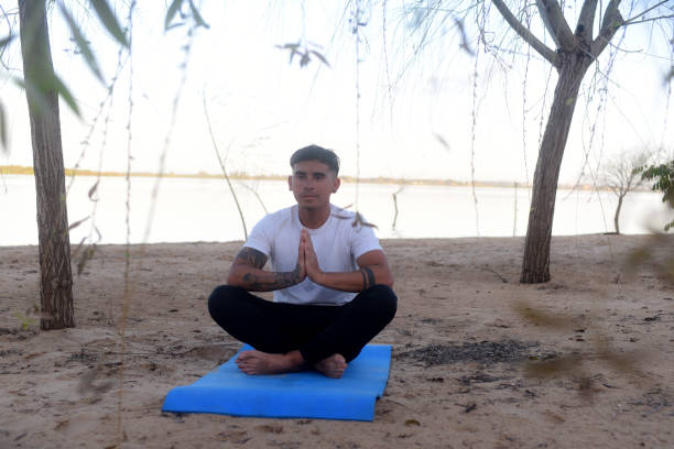 istock latin man doing yoga on the beach 1722851833