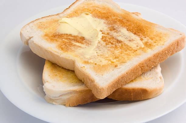 Freshly toasted bread smothered in creamy butter Toastand butter Piece of Toast stock pictures, royalty-free photos & images