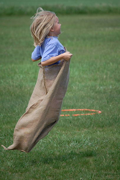 gunny corrida de saco - child playing sack race sports race - fotografias e filmes do acervo