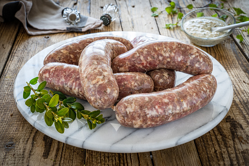 Uncooked white sausages on wooden table